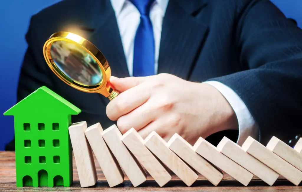 Брокер с лупа инспектира къща и правни рискове.