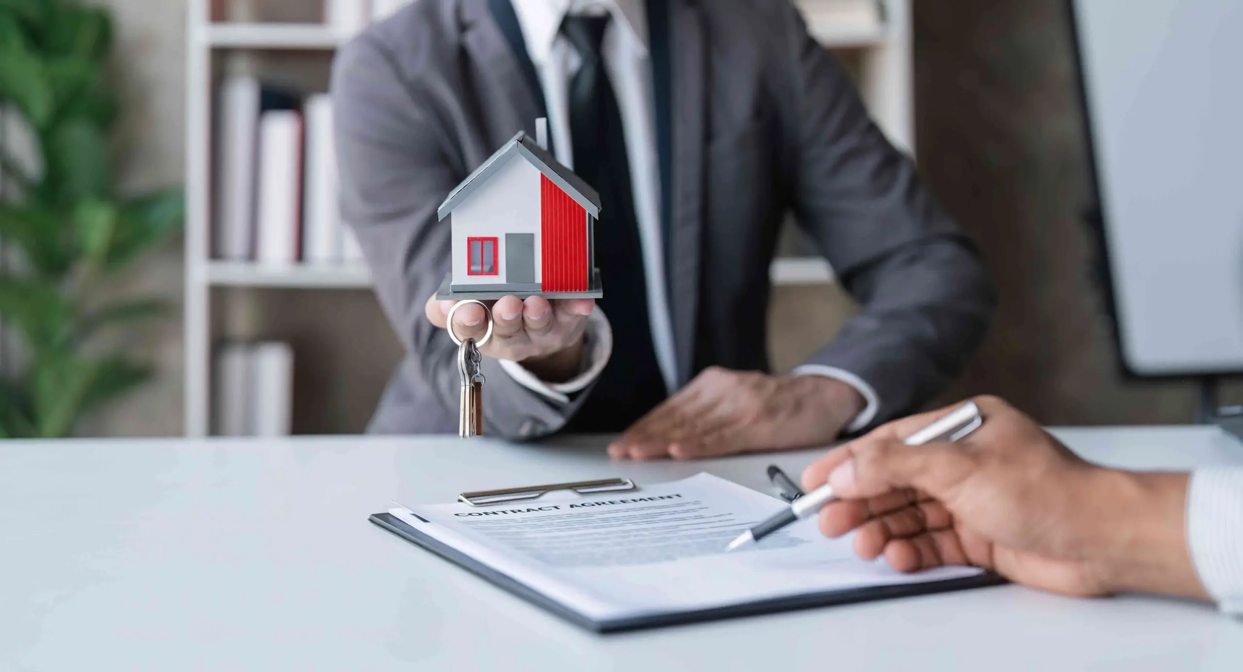 спешен брокер подава ключове на клиент при подписване на договор за имот